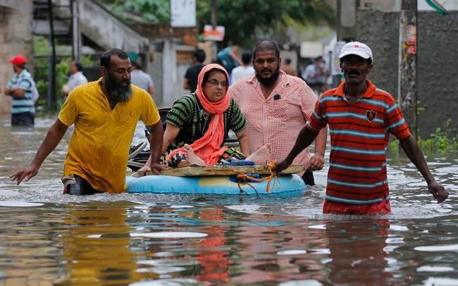 An elderly Sri Lankan woman is shifted on a makeshift raft at a flooded area in Colombo, Sri Lanka, Tuesday, May 17, 2016. 