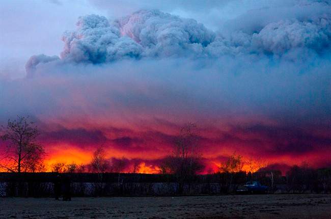 Clouds of ash rise into the atmosphere as fires rage across Fort McMurray.