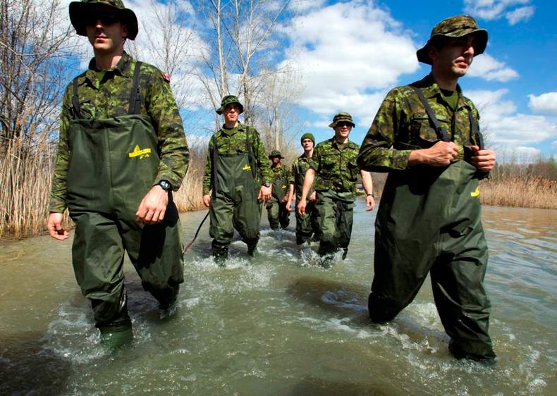 Soldiers from the Royal 22nd regiment, known as the Vandoos, wade through the flooded street along the Richelieu River, Monday, May 9, 2011 in Saint Blaise, Quebec.