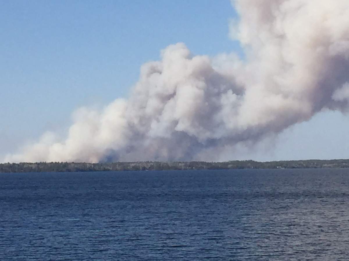 Thick smoke fills the sky north of West Hawk Lake.
