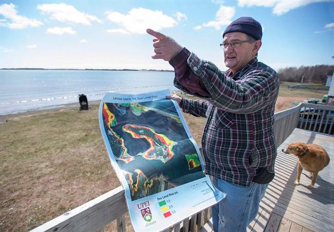 Dave Haley displays a map from the University of Prince Edward Island's climate research lab, showing sea level rise in Lennox Island, P.E.I. on Monday, April 25, 2016. Rising sea levels and coastal erosion threaten the Mi'Kmaq community which has seen a major loss of landmass in the last 50 years. THE CANADIAN PRESS/Andrew Vaughan.