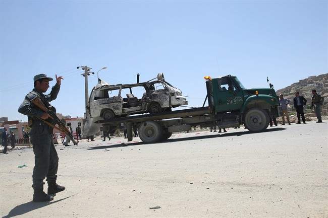 An Afghan police soldier stands guard near the destroyed vehicle at the site of a suicide attack in west of Kabul, Afghanistan, Wednesday, May 25, 2016. A suicide bomber targeted a vehicle carrying court employees in Kabul during morning rush hour on Wednesday, killing several people, an Afghan official said. The Taliban claimed responsibility for the attack. (AP Photo/Massoud Hossaini).