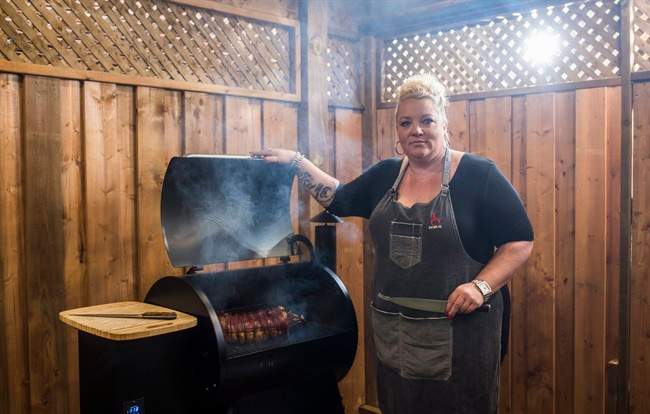 Danielle Bennett poses while cooking her "Filipino Style-Stuffed Pork Belly", a recipe in her cookbook "Diva Q's Barbecue," at the Dickson Barbecue Centre in Toronto, Wednesday May 18, 2016.