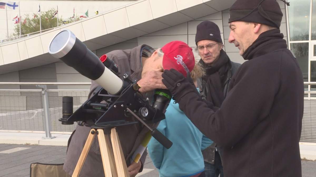 Montrealers take turns looking at the Mercury eclipse of the sun, Monday, May 9, 2016.
