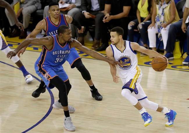 Golden State Warriors guard Stephen Curry (30) dribbles against Oklahoma City Thunder forward Kevin Durant (35) and guard Russell Westbrook during the first half of Game 7 of the NBA basketball Western Conference finals in Oakland, Calif., Monday, May 30, 2016. 