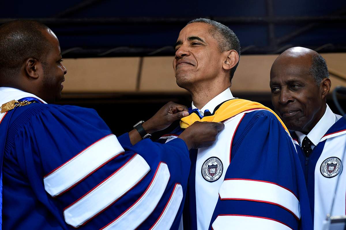 Howard University President Wayne A.I. Frederick, left, adjusts the sash of President Barack Obama, center, as he is awarded an honorary Doctor of Science degree from Howard University in Washington, Saturday, May 7, 2016, by Vernon Jordan, right.  