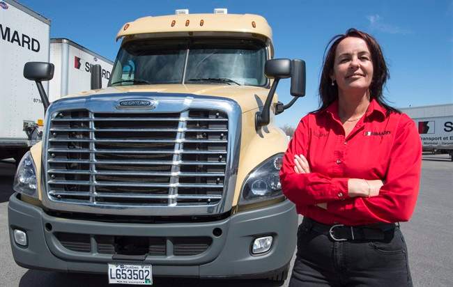 Truck driver Nadine Gauthier stands next to a truck Friday, May 6, 2016 in Montreal. Gauthier, a former truck driver, is working on behalf of Quebec's trucking association to encourage more women and girls to consider careers as truck drivers.
