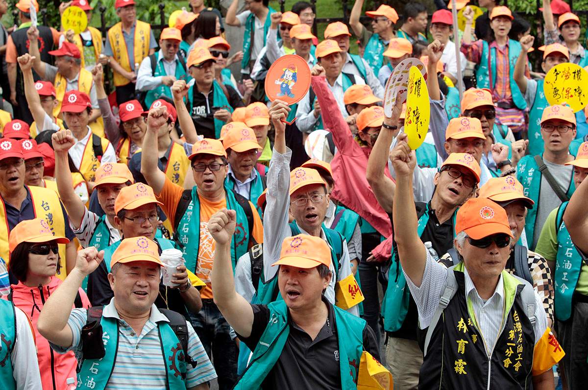 Taiwanese workers shout slogans during a May Day rally in Taipei, Taiwan, Sunday, May 1, 2016. Thousands of protesters from different labor groups protest on the street to ask for raising minimum wage and shorter working hours.