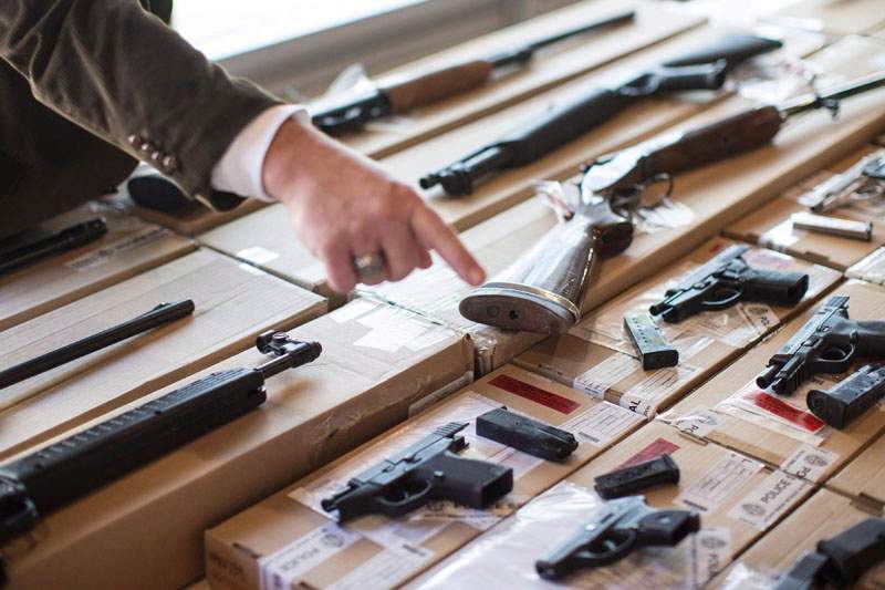 A police officer points out a fire arm as police display guns seized during a series of raids for operation "Project Traveller" at a press conference in Toronto on Friday, June 14, 2013. Police say a violent gang which was terrorizing a northwest Toronto neighbourhood has been dismantled following a series of raids targeting suspected drug and gun traffickers. THE CANADIAN PRESS/Chris Young.