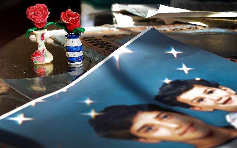 Prison artwork created by Adnan Syed sits near family photos in the home of his mother, Shamim Syed, in Baltimore. 