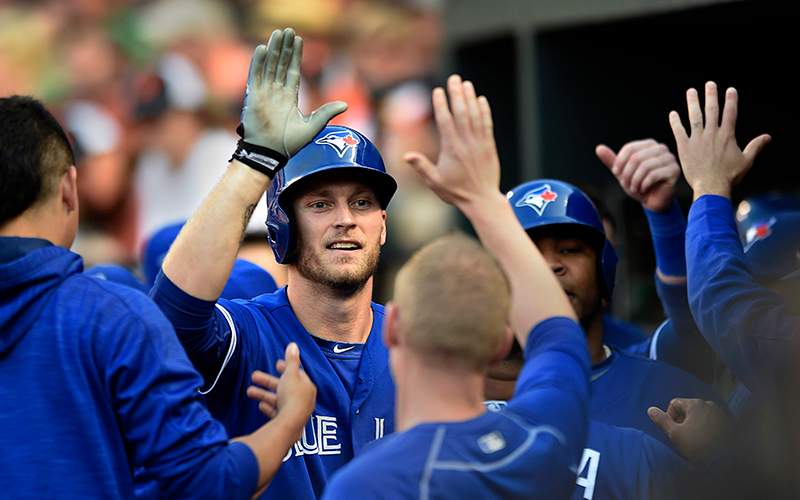 Toronto Blue Jays' Michael Saunders, center, is congratulated after hitting a three-run home run against the Baltimore Orioles in the first inning of a baseball game, Friday, June 17, 2016, in Baltimore. 