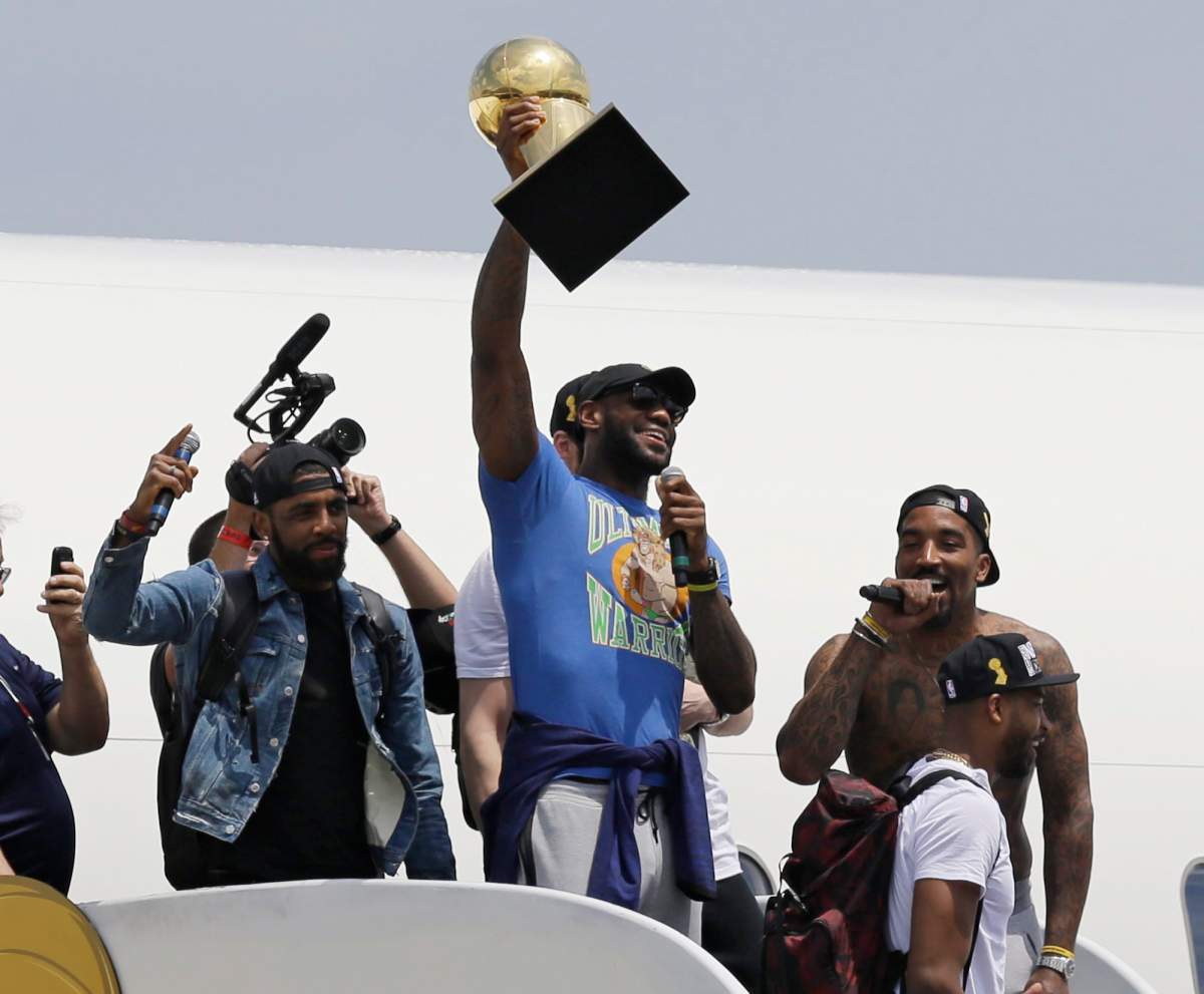 Cleveland Cavaliers' LeBron James holds up the Larry O'Brien Trophy after arriving in Cleveland, Monday, June 20, 2016. James came home with the trophy he promised, and the championship Cleveland has coveted for 52 years. The NBA superstar, born and raised in nearby Akron, stepped off a plane Monday and hoisted the shiny Larry O'Brien Trophy as more than 10,000 fans celebrated the city's first title since 1964. 