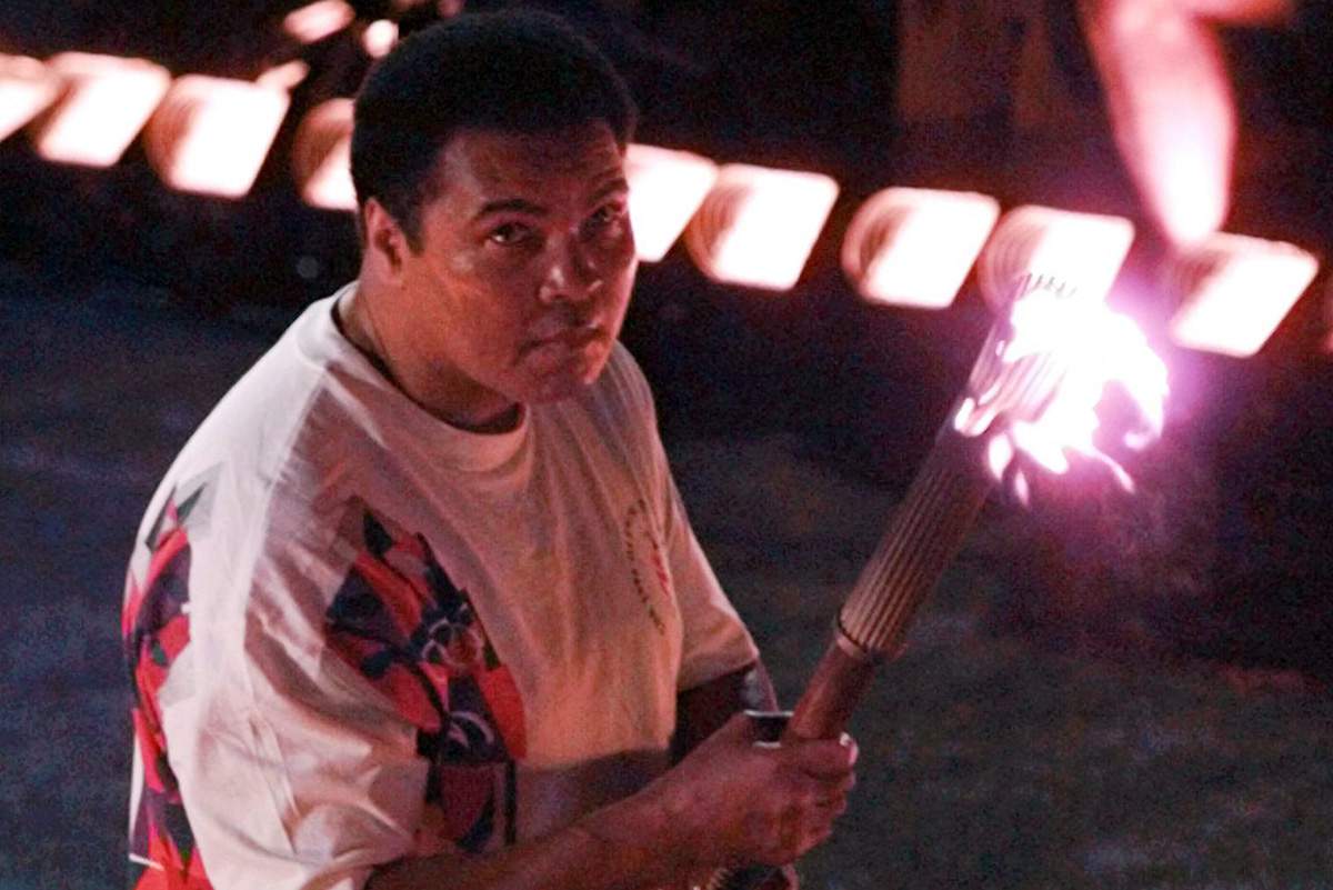 In this Friday, July 19, 1996 file photo, Muhammad Ali holds a torch as he watches as the flame climb up to the Olympic cauldron during the opening ceremonies of the Summer Olympics in Atlanta.