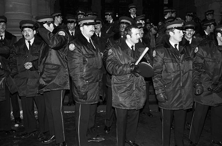 Police officers stand on the steps of the Ontario Legislature in Toronto in the early hours of Feb. 7, 1981 after gay rights demonstrators marched there in protest of the arrests of hundreds of men on Feb. 5, 1981 of in four city bathhouses.