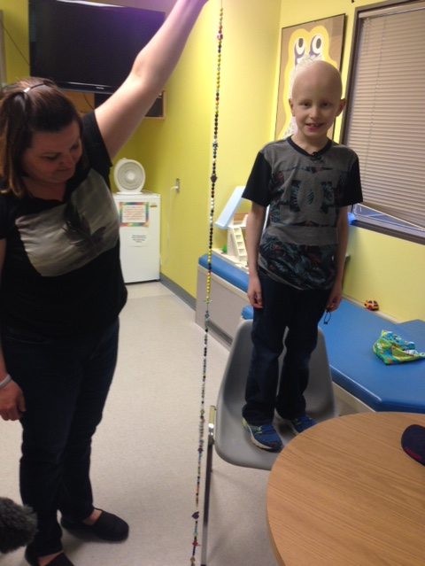 Joel Bachman’s necklace is longer than he is tall, symbolizing his long journey with cancer.