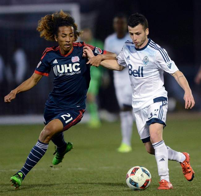 New England Revolution midfielder Zachary Herivaux (21) and Vancouver Whitecaps midfielder Marco Bustos vie for possession during an MLS preseason soccer game in 2016. Bustos is leaving Winnipeg.