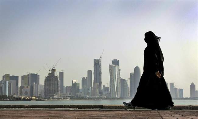 A Qatari woman walks in front of the city skyline in Doha, Qatar in a 2010 file photo.