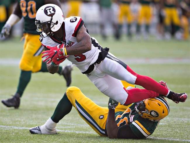 Ottawa Redblacks Travon Van (3) is tackled by Edmonton Eskimos Deon Lacey (40) during second half CFL action in Edmonton, Alta., on Saturday, June 25, 2016. 