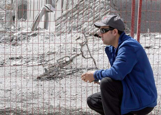 Farid El-Hayouni looks at the charred remains of his son's bike in Fort McMurray, Alta. on Friday, June 3, 2016.
