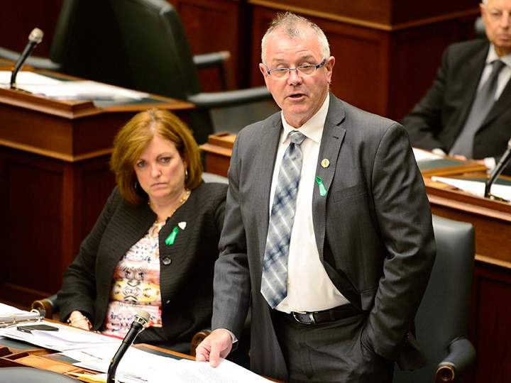Ontario Labour Minister Kevin Flynn tables back to work legislation for striking secondary school teachers at the legislature in Toronto, Monday, May 25, 2015 as Liberal MPP Eleanor McMahon looks on. 