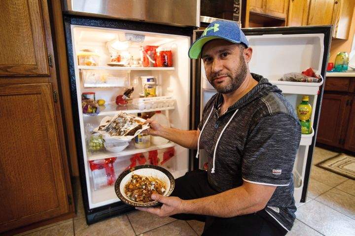Bachir Kourani shows mouldy dishes from his refrigerator after returning to the city as residents re-enter fire-ravaged Fort McMurray, Alta., on Wednesday, June 1, 2016.