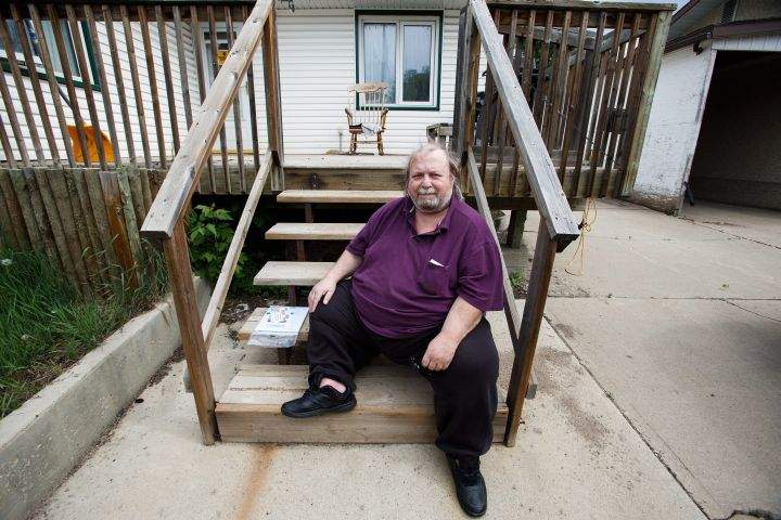 Dave Chalupa sits on his front step moments after returning to the city as residents re-enter fire-ravaged Fort McMurray, Alta., on Wednesday, June 1, 2016.