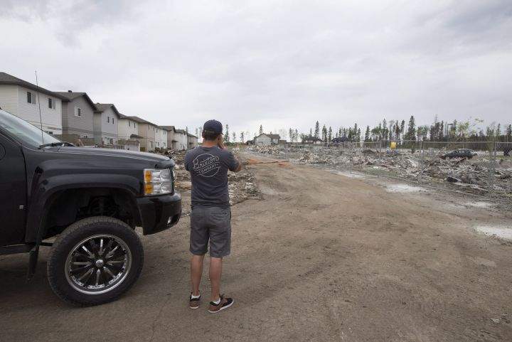 A resident of Fort McMurray looks over the damage to the neighbourhood of Timberlea in Fort McMurray. Alta., on Wednesday, June 1, 2016. Residents began returning to their homes after being evacuated due to wildfires.