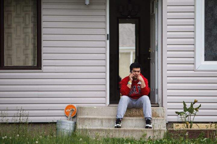 Russell Boston sits on the front steps of his home moments after returning as residents re-enter fire-ravaged Fort McMurray, Alta., on Wednesday, June 1, 2016.