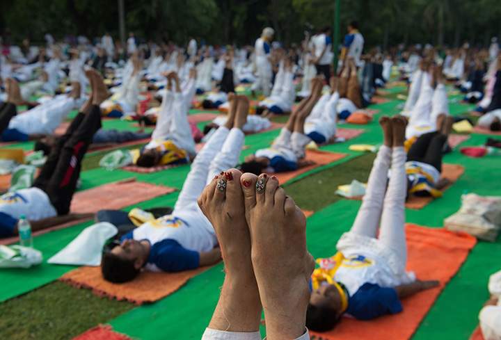 An Indian woman points her toes upwards in a morning yoga session held to mark International Yoga Day in Lodhi Gardens in New Delhi on June 21, 2016.