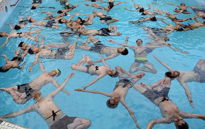 People take part in a yoga session in a swimming pool on International Yoga Day in Jodhpur, India on June 21, 2016.