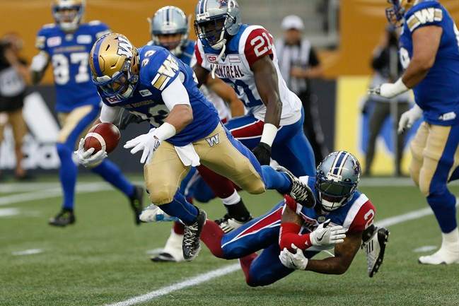 Despite Montreal Alouettes' Jovon Johnson (2) getting a hand on Winnipeg Blue Bombers' Andrew Harris (33) he can't stop the running back during the first half of pre-season CFL action in Winnipeg Wednesday, June 8, 2016. THE CANADIAN PRESS/John Woods.