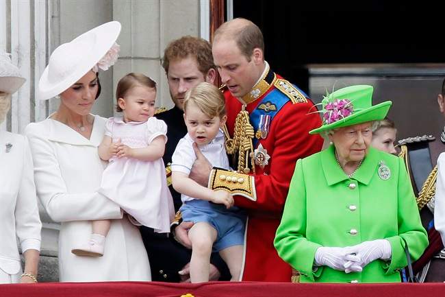 Britain's Queen Elizabeth II, right, with Prince William holding Prince George, centre, and Kate, Duchess of Cambridge holding Princess Charlotte, left, on the balcony during the Trooping The Colour parade at Buckingham Palace, in London, Saturday, June 11, 2016.