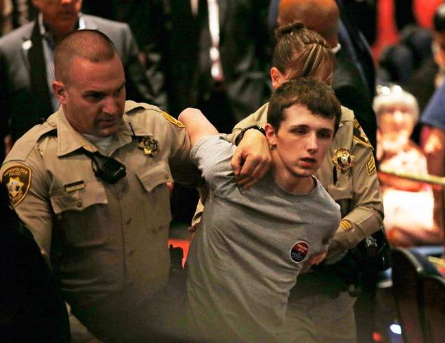 In this June 18, 2016, photo, police remove Michael Steven Sandford as Republican presidential candidate Donald Trump speaks at the Treasure Island hotel and casino in Las Vegas. 