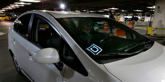 This March 31, 2016, file photo shows a driver for Uber Technologies Inc., arriving at an authorized customer pick up area at Seattle-Tacoma International Airport in Seattle.