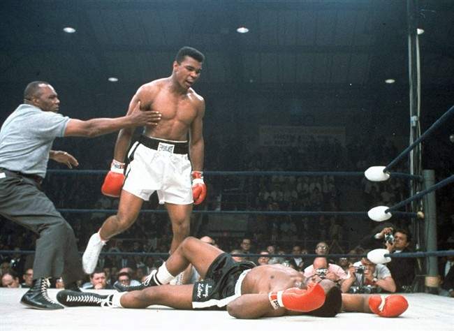 In this May 25, 1965, file photo, heavyweight champion Muhammad Ali is held back by referee Joe Walcott, left, after Ali knocked out challenger Sonny Liston. (AP Photo/File)