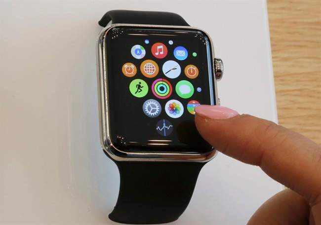 In this April 10, 2015, file photo, a customer demonstrates the Apple Watch at an Apple Store in Tokyo. 