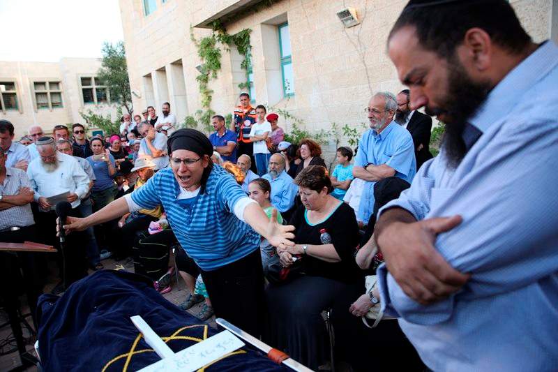 Rina Ariel weeps over the body of her slain 13 year old daughter Hallel during her funeral inside a Jewish settlement of Kiryat Arba, West Bank, Thursday, June 30, 2016. 