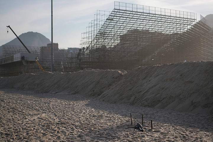 A human foot is covered with a black plastic after it was found on the beach in front of the Olympic beach volleyball venue still under construction at Copacabana in Rio de Janeiro, Brazil, Wednesday, June 29, 2016. 