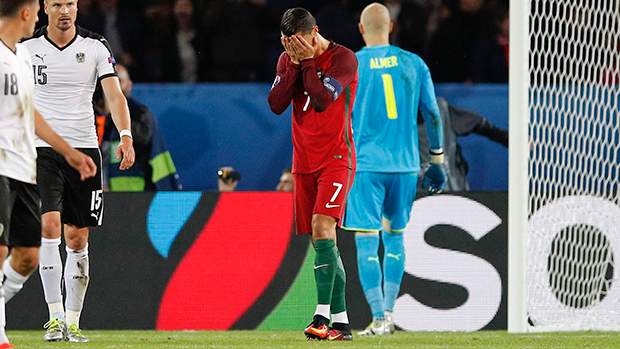 Portugal's Cristiano Ronaldo, center, holds his face after missing a penalty kick, during the Euro 2016 Group F soccer match between Portugal and Austria at the Parc des Princes stadium in Paris, France, Saturday, June 18, 2016. (AP Photo/Christophe Ena)