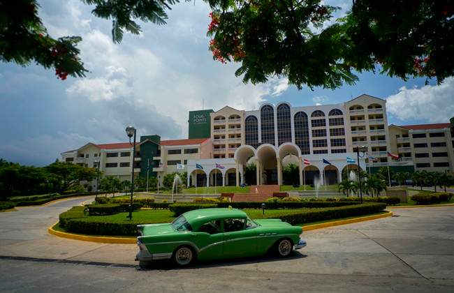 A vintage car passes in front of the Four Points by Sheraton hotel in Havana, Tuesday, June 28, 2016.