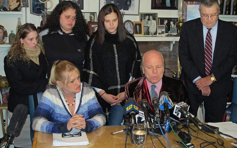 Attorney John Ray, seated next to Mari Gilbert. Standing, from left, are Gilbert's sisters, Stevie Smith, Sarra Gilbert, and Sherre Gilbert. 