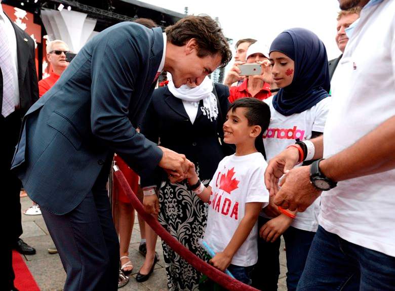 Prime Minister Justin Trudeau greets members of a Syrian refugee family during Canada Day celebrations on Parliament Hill.