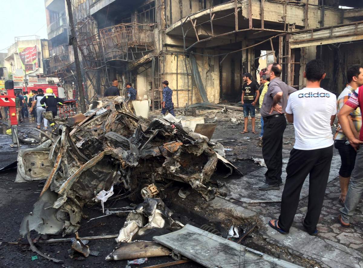 Iraqi security forces and civilians gather at the site after a car bomb at a commercial area in Karada neighborhood, Baghdad, Iraq, Sunday, July 3, 2016.