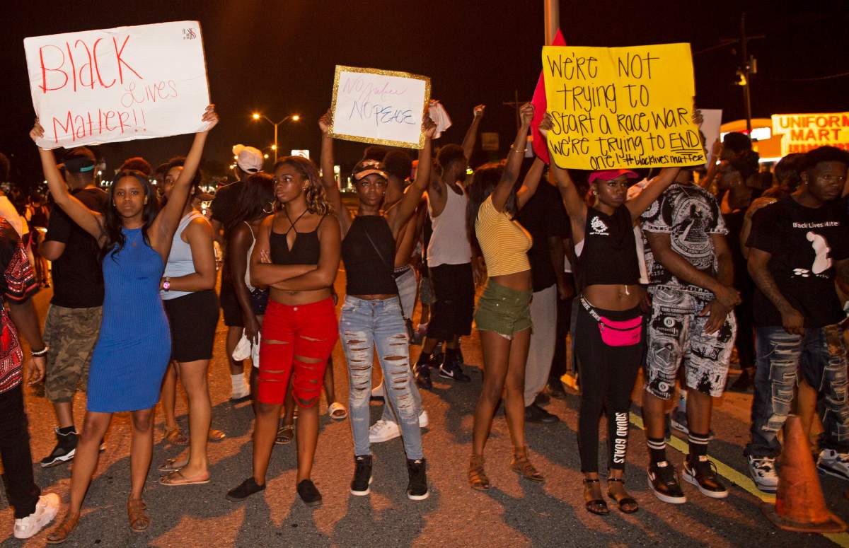 Protesters block Airline Highway, a major road that passes in front of the Baton Rouge Police Department headquarters, Saturday, July 9, 2016, as they protest the shooting death of a black man, Alton Sterling, by two white police officers at a convenience store parking lot last week in Baton Rouge, La. ()