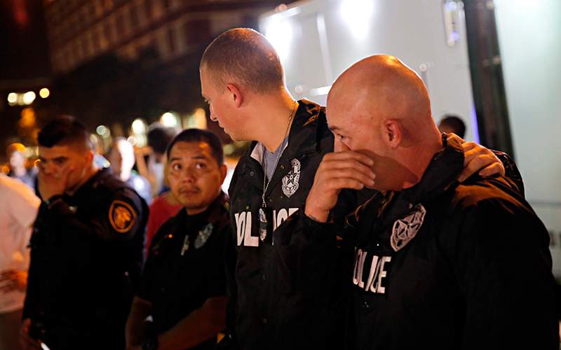 Dallas Police Department officers visit a memorial in front of police headquarters, in Dallas. Five police officers were killed the previous evening when a sniper opened fire on a Black Lives Matter rally downtown. 