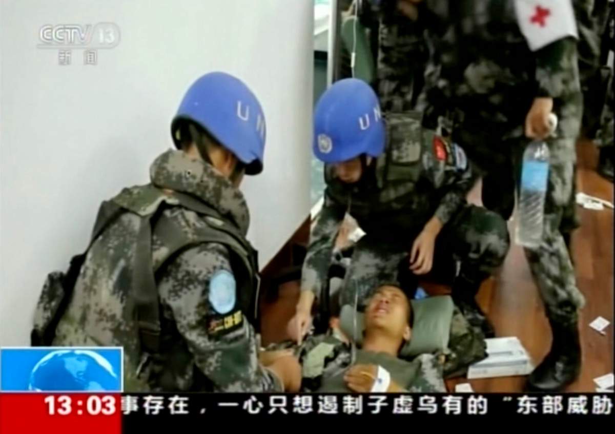 In this image taken from a July 10, 2016, video footage released by China’s CCTV via AP Video, Chinese UN peacekeepers tend to a wounded colleague after an attack on an armored personal carrier used by the Chinese peacekeepers in Jebel in South Sudan. Heavy explosions are shaking South Sudan’s capital Juba Monday, July 11, 2016, as clashes between government and opposition forces entered their fifth day, witnesses say, pushing the country back toward civil war.