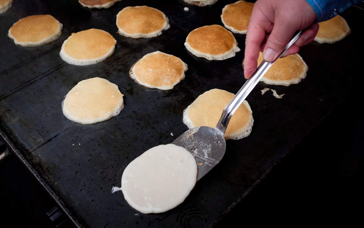 Pancakes are cooked at the annual Premier’s Stampede Breakfast in Calgary, Alta., Monday, July 11, 2016.THE CANADIAN PRESS/Jeff McIntosh