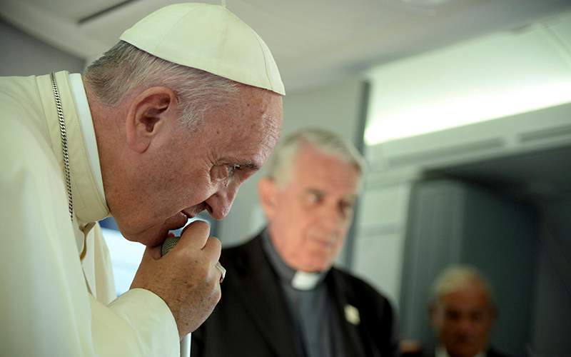 Pope Francis listens to a journalist's question on board the flight from Krakow, Poland, to Rome, at the end of his 5-day trip to southern Poland, Sunday, July 31, 2016. 