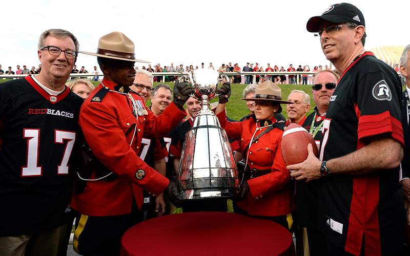 Mayor Jim Watson, left, and Roger Greenberg, right, look on as Ottawa is announced as the host of the 2017 Grey Cup championship, before CFL action between the Ottawa Redblacks and the Toronto Argonauts, in Ottawa on Sunday, July 31, 2016.