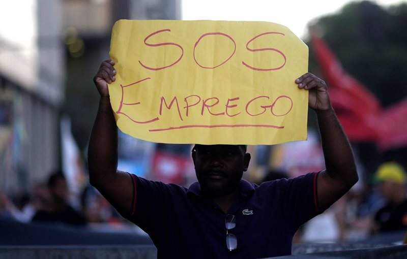 A man holds a banner which reads "S.O.S. employment" as he attends a protest on the Rio de Janeiro economic crisis, Brazil, July 6, 2016. Picture taken July 6, 2016. REUTERS/Ricardo Moraes.